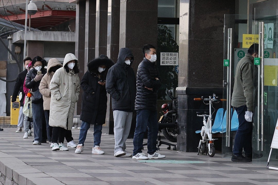 在中国陕西省西安的一家药房外，民众周二大排长龙等著购买抗原检测试剂盒。（图取自法新社）