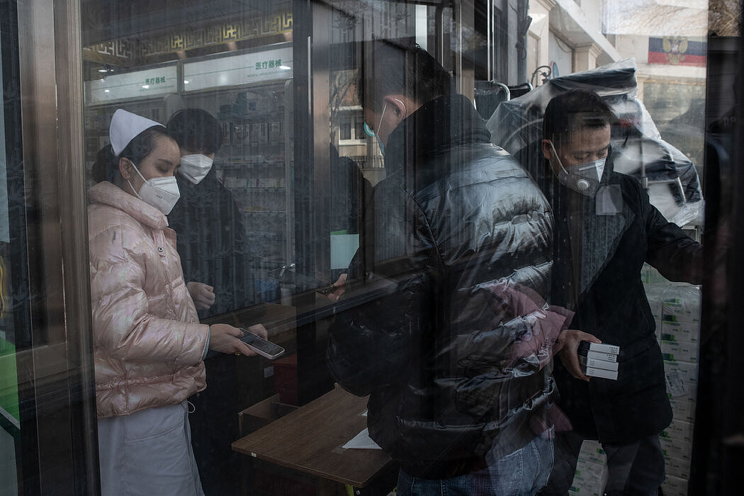 在北京一家药店排队买药的民众，摄于周二。随着新冠病毒疫情暴发的迹象出现，全国各地的药店都出现了抢购现象。