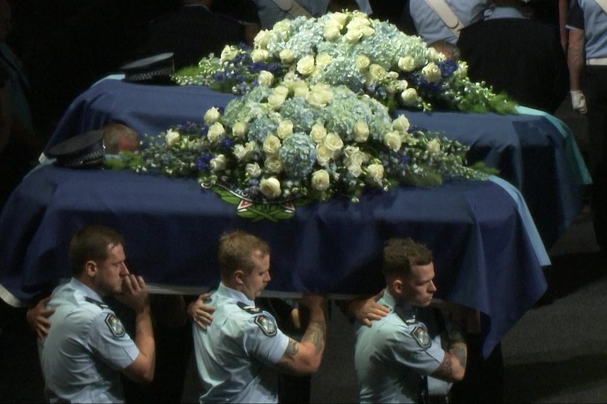 The coffins of Constables Rachel McCrow and Matthew Arnold carried away by officers.