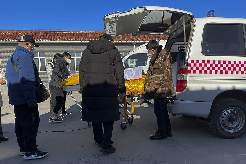河北省高碑店市殡仪馆工作人员，22日从救护车中搬出一具遗体准备火化。(美联社)