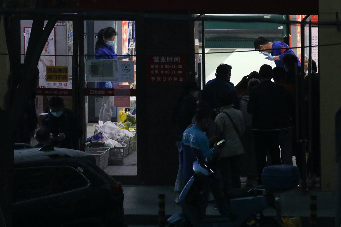 北京市一家超市门口，市民和配送员等候购买商品。 （视觉中国）