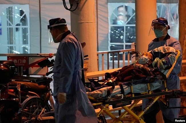 上海医护人员在运送一名病人进入医院的发热门诊。（2022年12月19日）