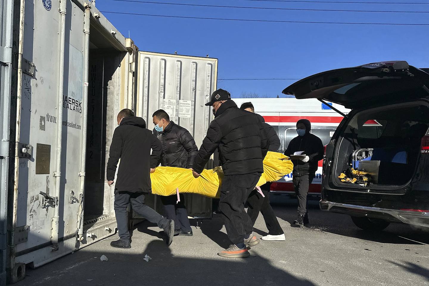 12月17日，北京火葬場工作人員運送遺體。(AP)