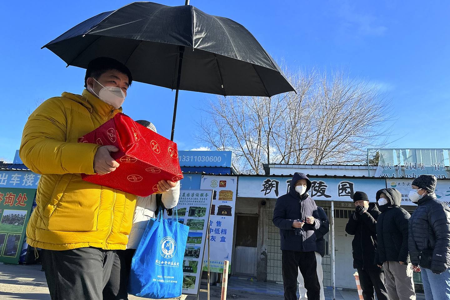 12月17日，北京市民在火葬场外捧着亲人火化后的骨灰。 (AP)