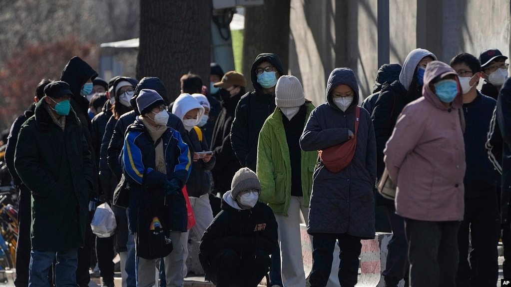 北京居民在一所医院的发热门诊前大排长龙。（美联社2022年12月11日照片）