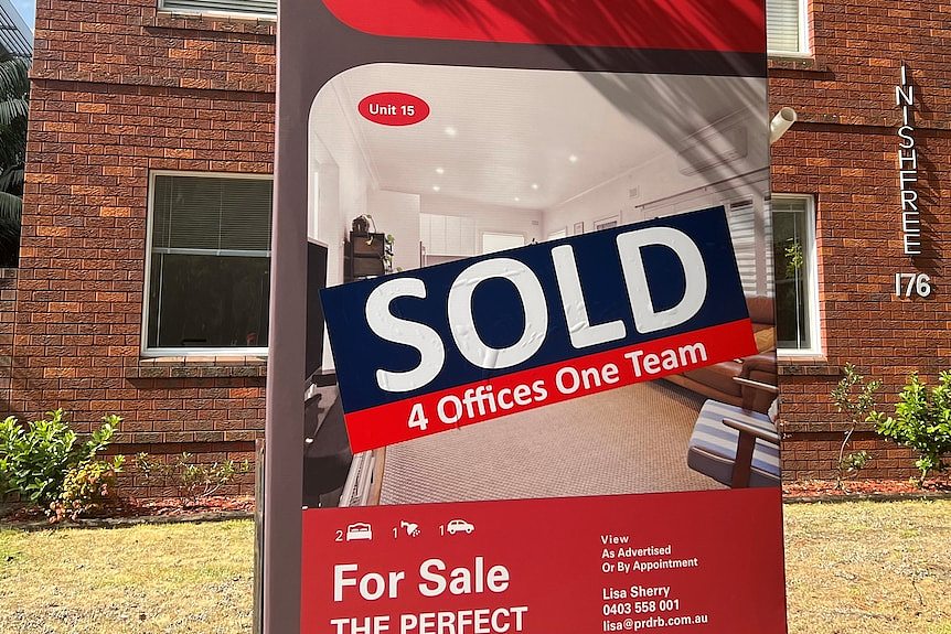 A sold sign out the front of an older red brick apartment block in Sydney's south.