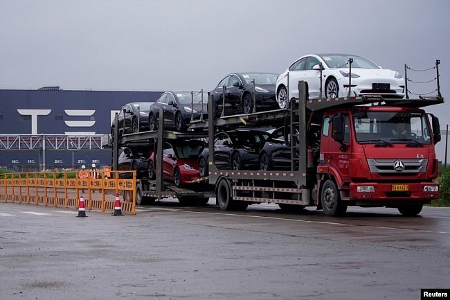 一辆大卡车运出特斯拉上海工厂出产的汽车。（2021年5月13日）