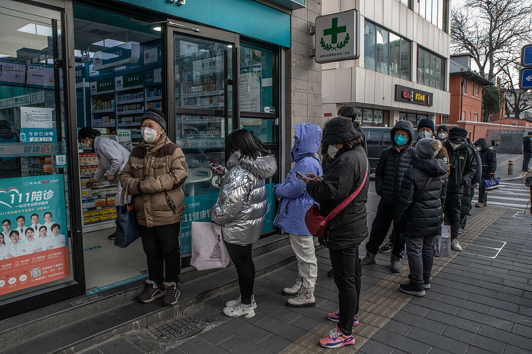 在北京一家药店排队的民众。感染激增导致退烧药品短缺。