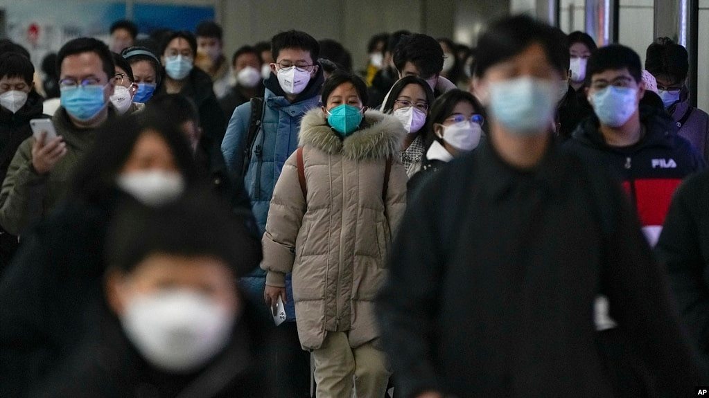 资料照 - 2022年12月20日的北京街头，带口罩的通勤者在交通高峰期匆忙赶去上班。在突然放开了执行将近3年的严格封控政策后，中国多地新冠感染病例暴增，并且出现了奥密克戎病毒的变异毒株。