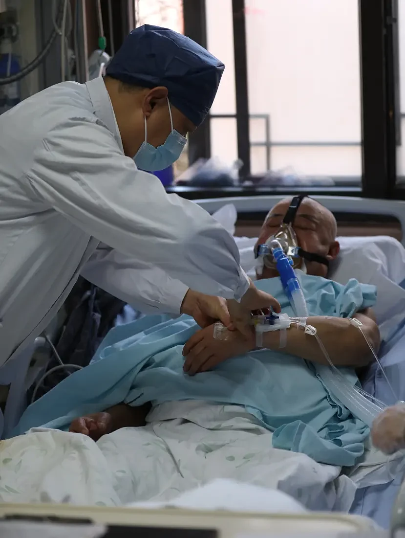 12月24日，北京中医医院党委副书记、院长刘清泉为综合重症监护室的患者把脉。曹子豪摄