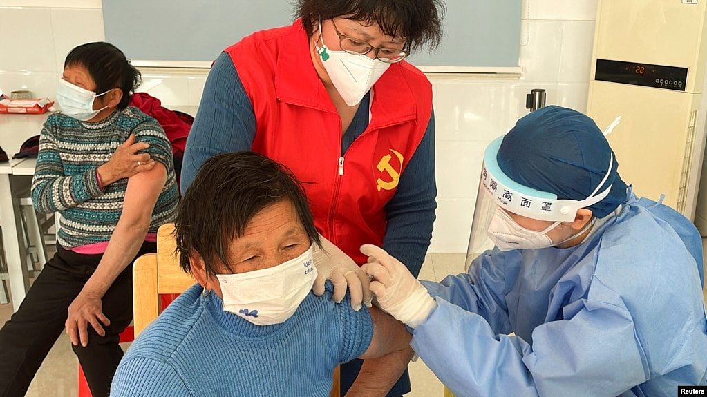 中国医护人员在上海郊区的村庄里为老年人接种新冠疫苗。（2022年12月21日）