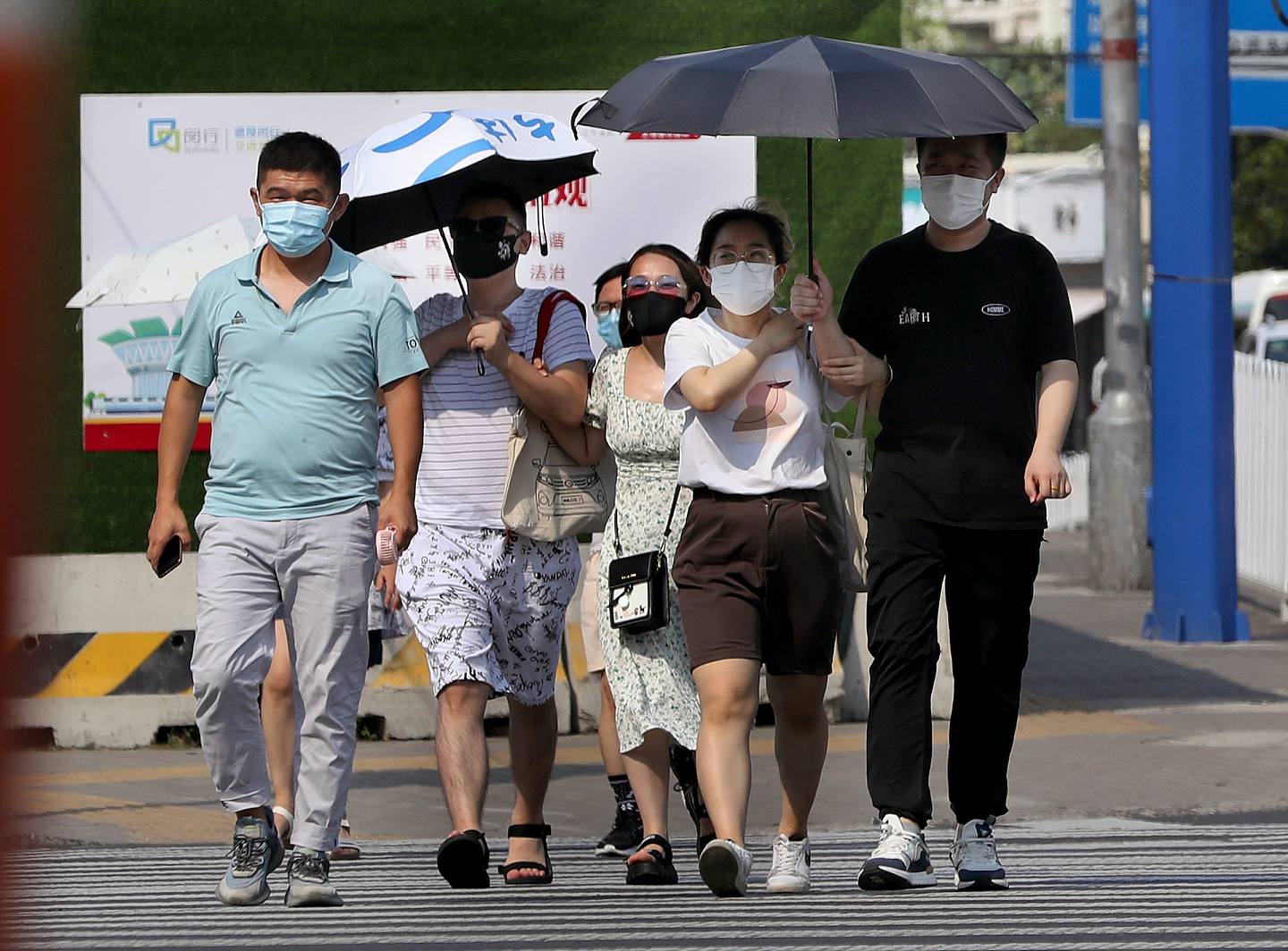 7月10日，在上海市閔行區，行人在烈日下行走。（新華社）