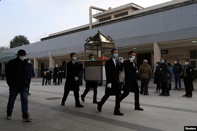 四川成都一个火葬场工作人员抬着一名逝者的骨灰盒走出火葬场。(2022年12月28日)