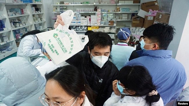 人们在杭州一家药店排队购买新冠病毒抗原检测试剂盒。（2022年12月19日）