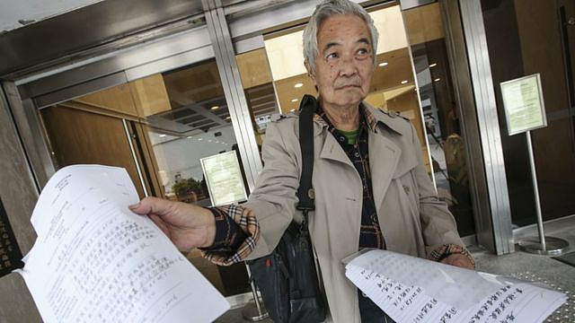 郭卓坚在香港高等法院门外向记者展示起诉文书（资料图片）