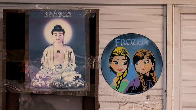 郭卓坚办公室内挂于墙上的观音菩萨像（左）与画上迪士尼卡通人物的旧黑胶唱片（右）