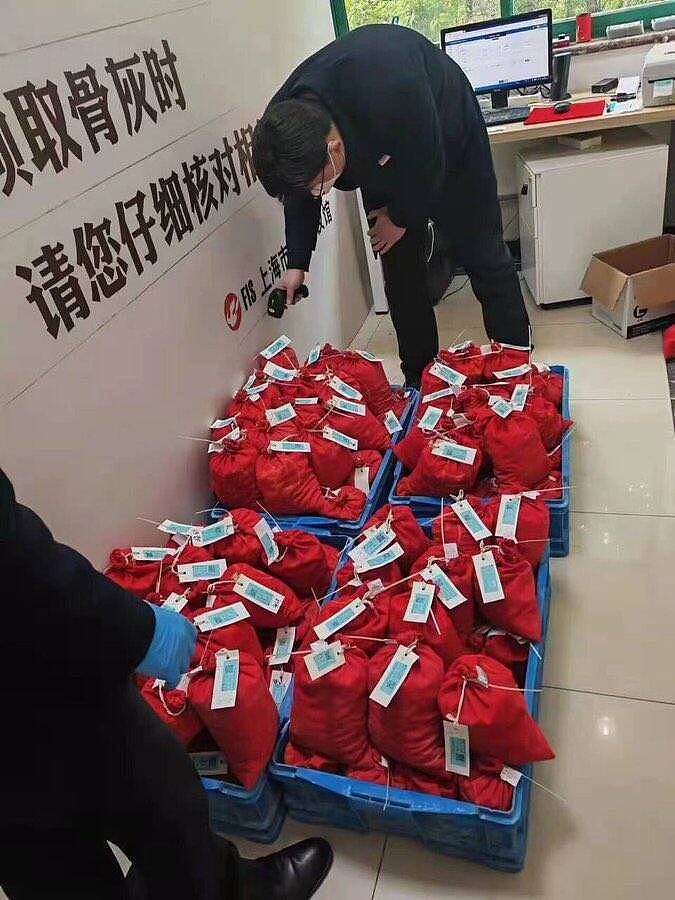 上海殡葬业者将骨灰袋放在塑胶篮中供民众自取，显示上海疫情严峻。 （图撷取自「@zhangyi6683」推特）