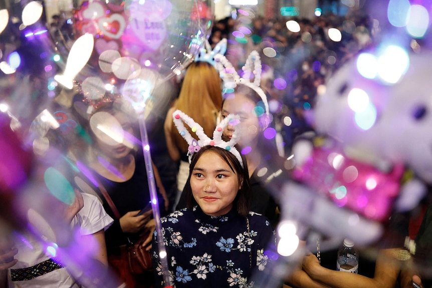 在吉隆坡，一名狂欢者戴着兔耳朵庆祝新年前夜。