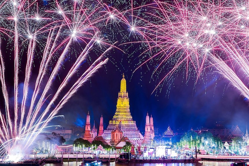 在曼谷的新年庆祝活动中，烟花在黎明寺的郑王庙上空绽放。