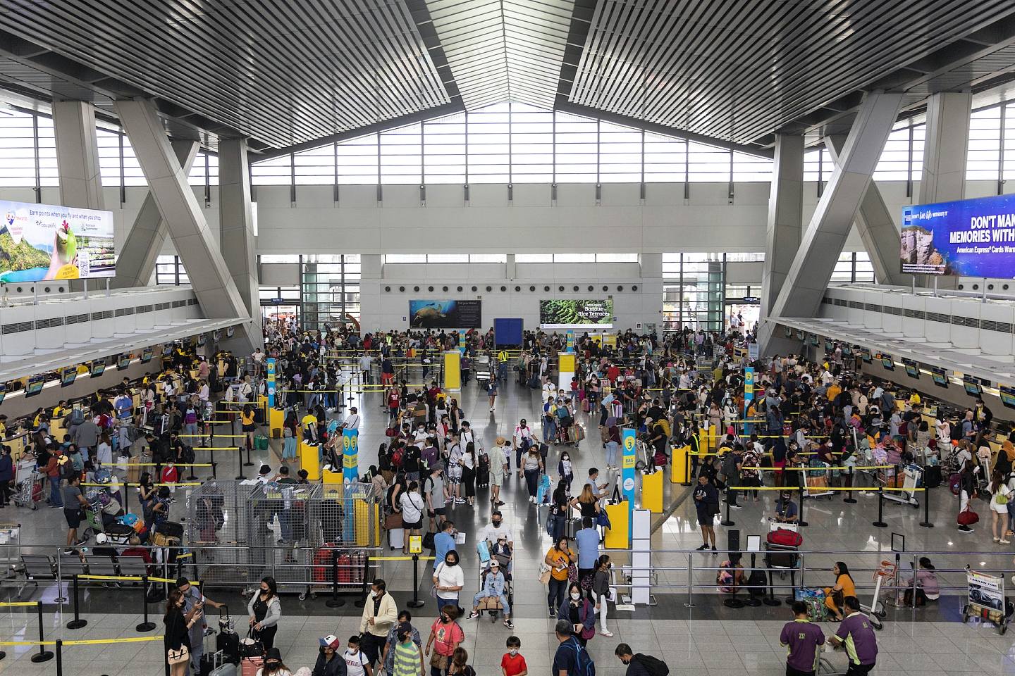1月1日發生大停電的菲律賓馬尼拉國際機場，翌日仍有大量航班急需處理。圖為2022年1月2日機場客運大樓內，各個航空公司的櫃檯大排長龍。（Reuters）