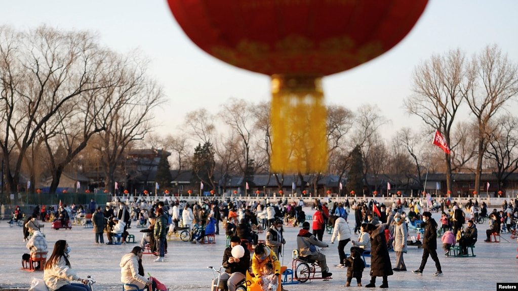 北京居民在冰封的湖面上滑冰玩耍。（2022年12月31日）