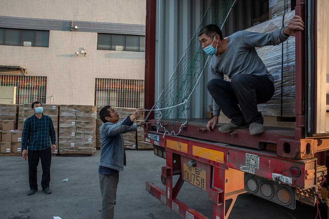 阳江，徐泽强（左）看着他的卡车装满出口货物。