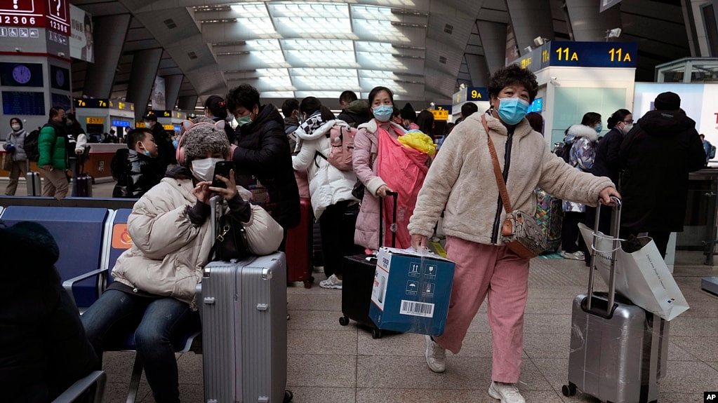 北京南站戴着口罩的旅客在候车室里等待。（2022年1月14日）