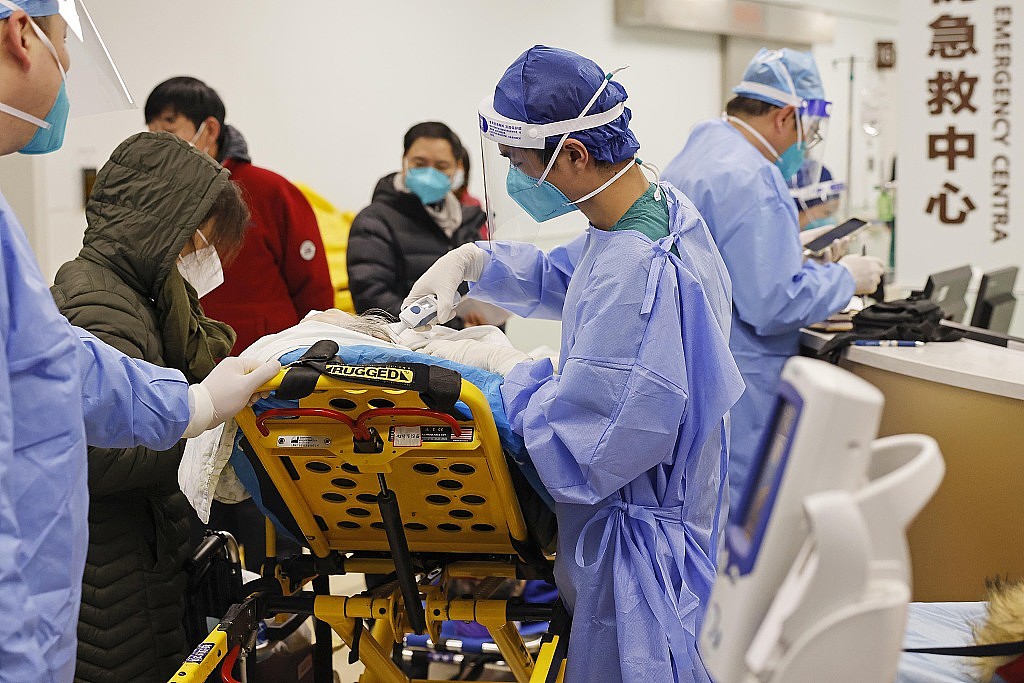 2022年12月31日晚，上海市第一人民医院松江院区内，医护人员为患者进行体温检测。中新社记者 殷立勤 摄