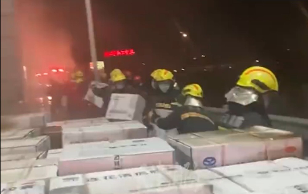 消防员接力救出将近1140箱药品。 网图