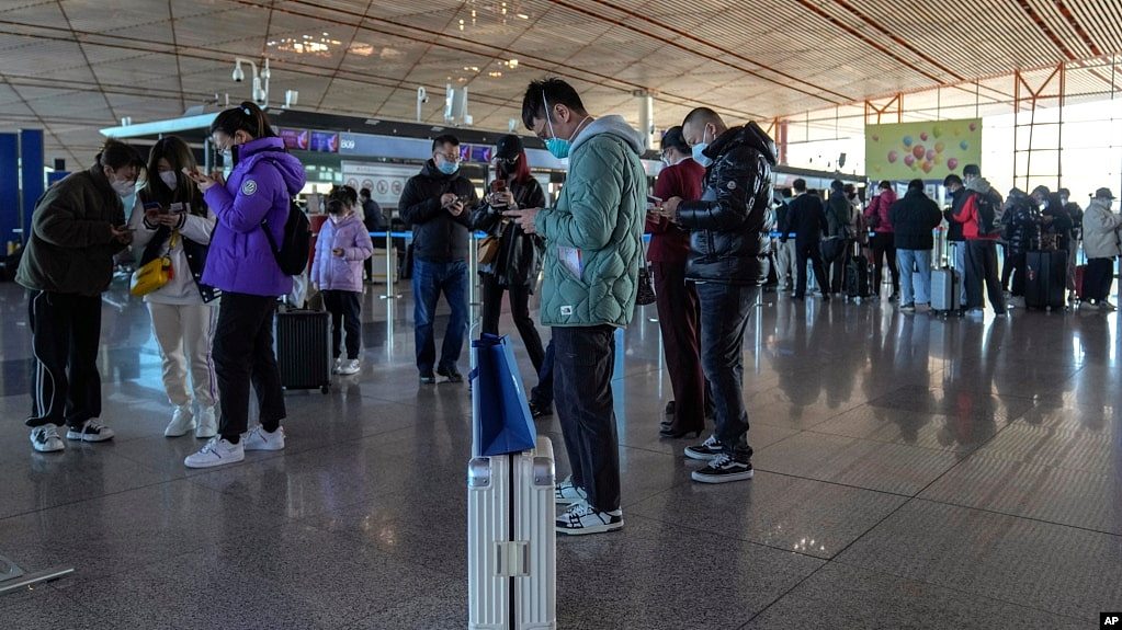 旅客在北京首都国际机场国际航班值机柜台办理登机手续后使用智能手机填写健康申明。（2022年12月29日，资料照片）