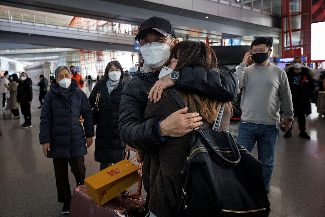 中国周日开放边境后，人们在北京国际机场的国际到达口迎接亲朋。