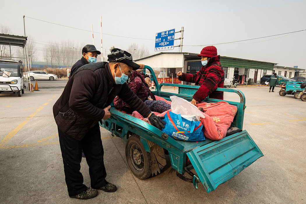 周四在中国中部，一名女子被人抬上了一辆三轮摩托，他们刚从县医院出来。随着新冠病毒的广泛传播，资金不足的农村医疗保健系统可能不堪重负。