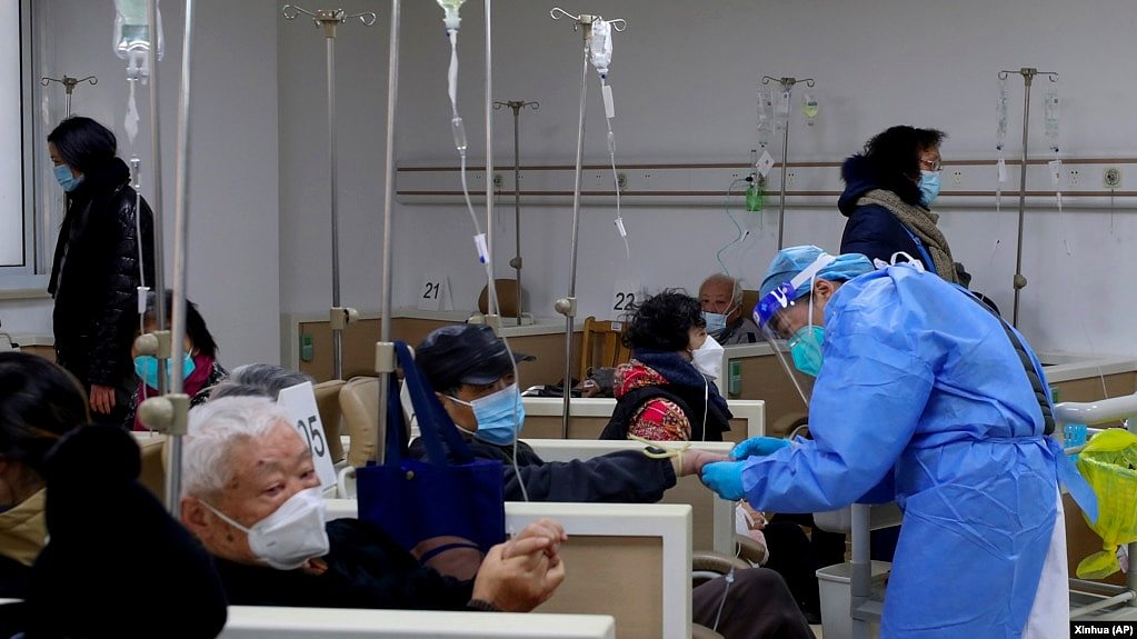 上海一家医院的医护人员正在帮助一名病人打点滴。（2023年1月5日）