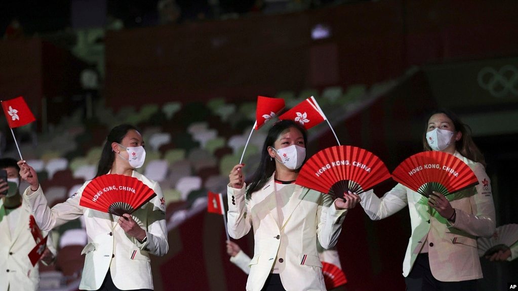 资料照 - 2021年在东京举行的2020东京夏季奥运会开幕式上，香港代表队队员手举香港区旗和印有“香港·中国”英文字的红色扇子走进场内。