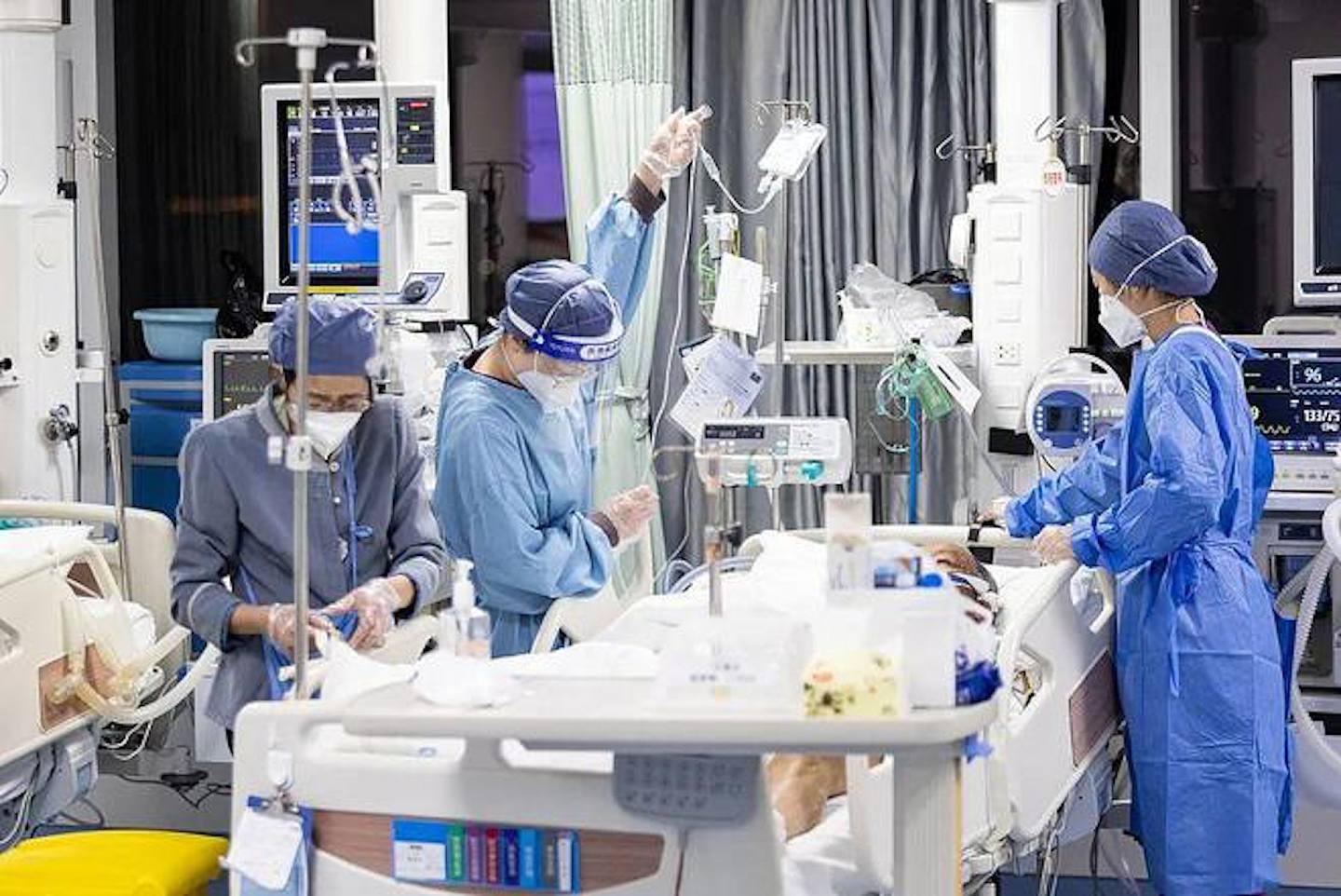 浙江湖州市中心医院呼吸重症监护病房内，医护人员正为患者护理。 （《中国新闻周刊》）