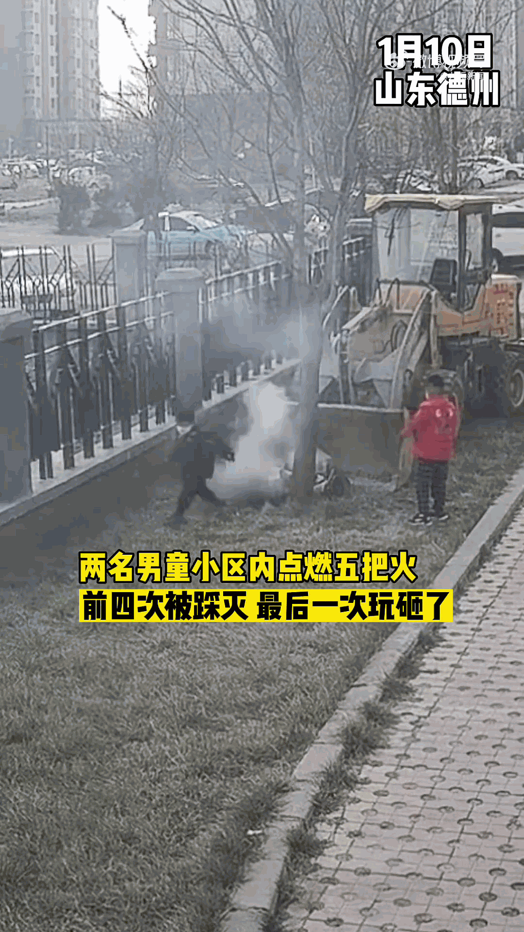 两名小童在社区一辆铲车后玩火，其中一名更在燃烧中的杂草上尝试将火踩熄。