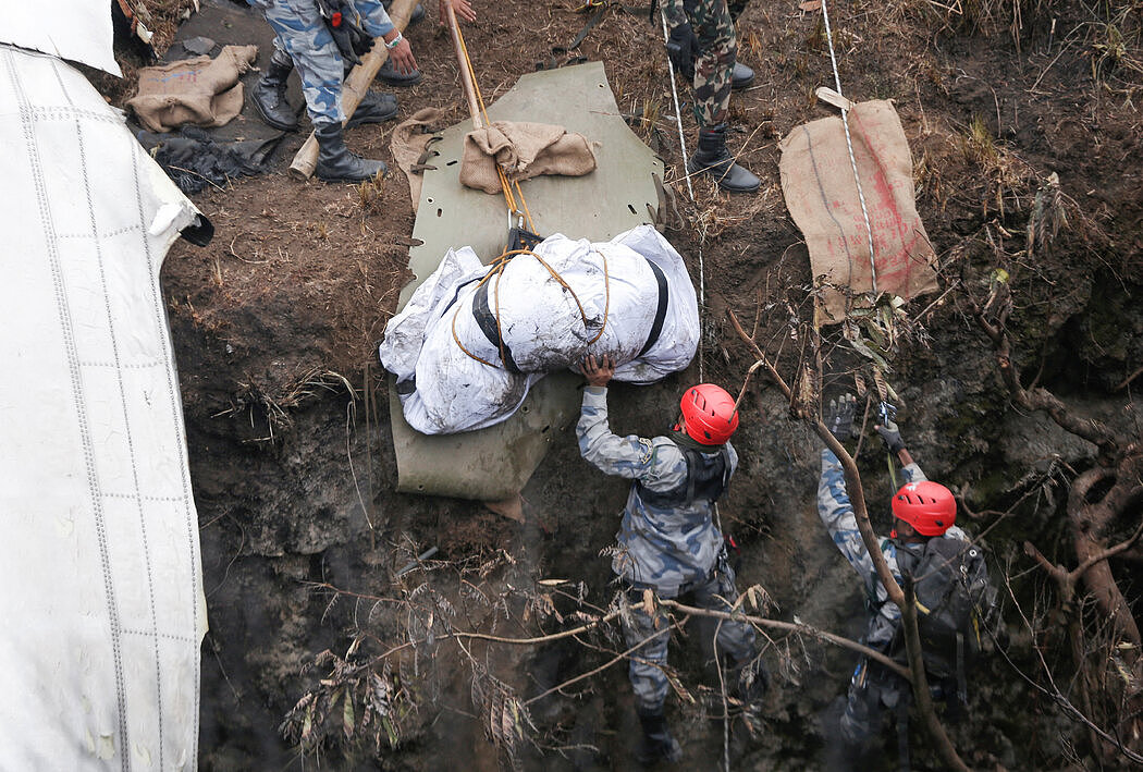救援队寻回一名遇难者的遗体。周一，工作人员找到了黑匣子。