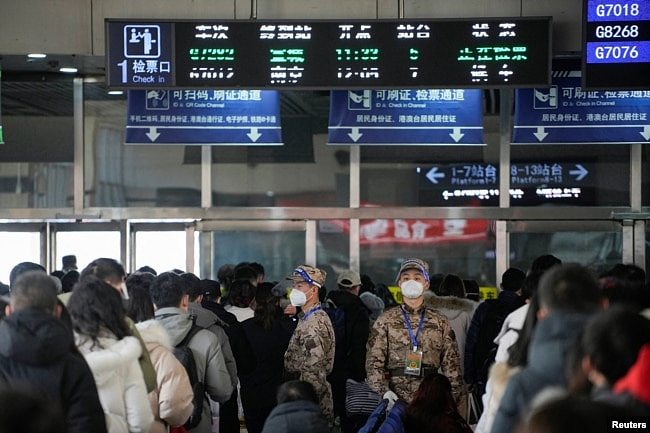 中国武警士兵在上海火车站里指挥春运人潮排队等候。（2023年1月16日）