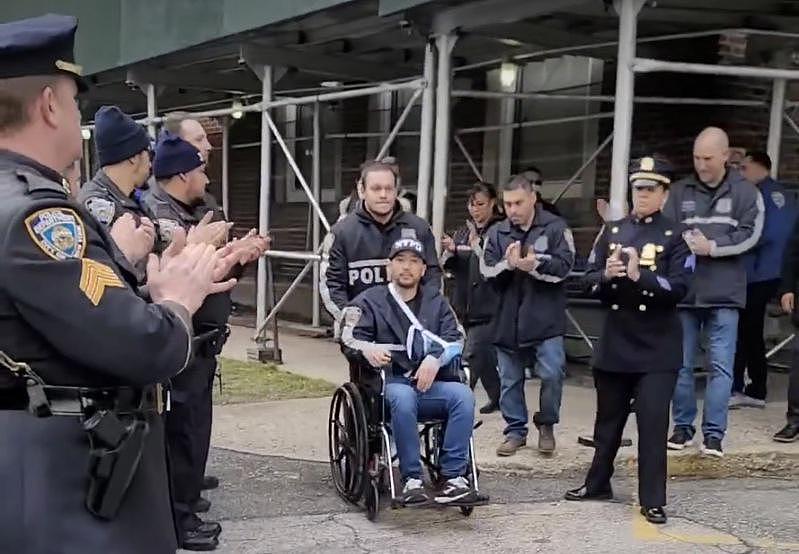 華警李保羅在家人和同事的陪同下出院，警分局警員列隊歡迎。(紐約市警方提供)