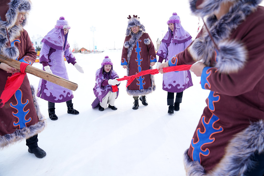 抚远市乌苏镇抓吉赫哲族村，赫哲族青年在雪地上娱乐。 新华社