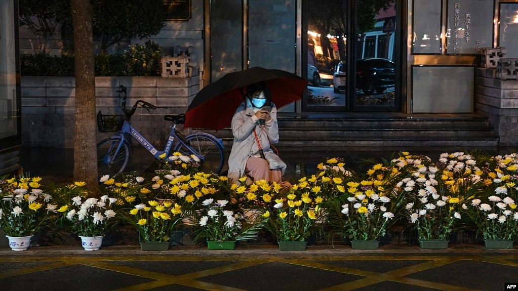 2023年1月21日，中国中部湖北省武汉市，一名沿街卖花的妇女在农历新年前夕等待顾客。