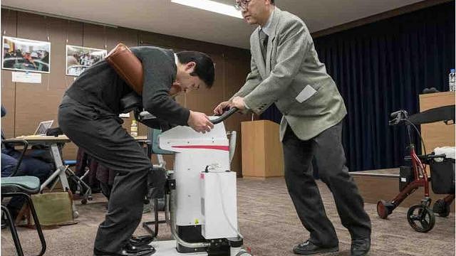 2018年2月，日本东京展示的与机器人护理师（即移动支援机器人）拥抱的照片。