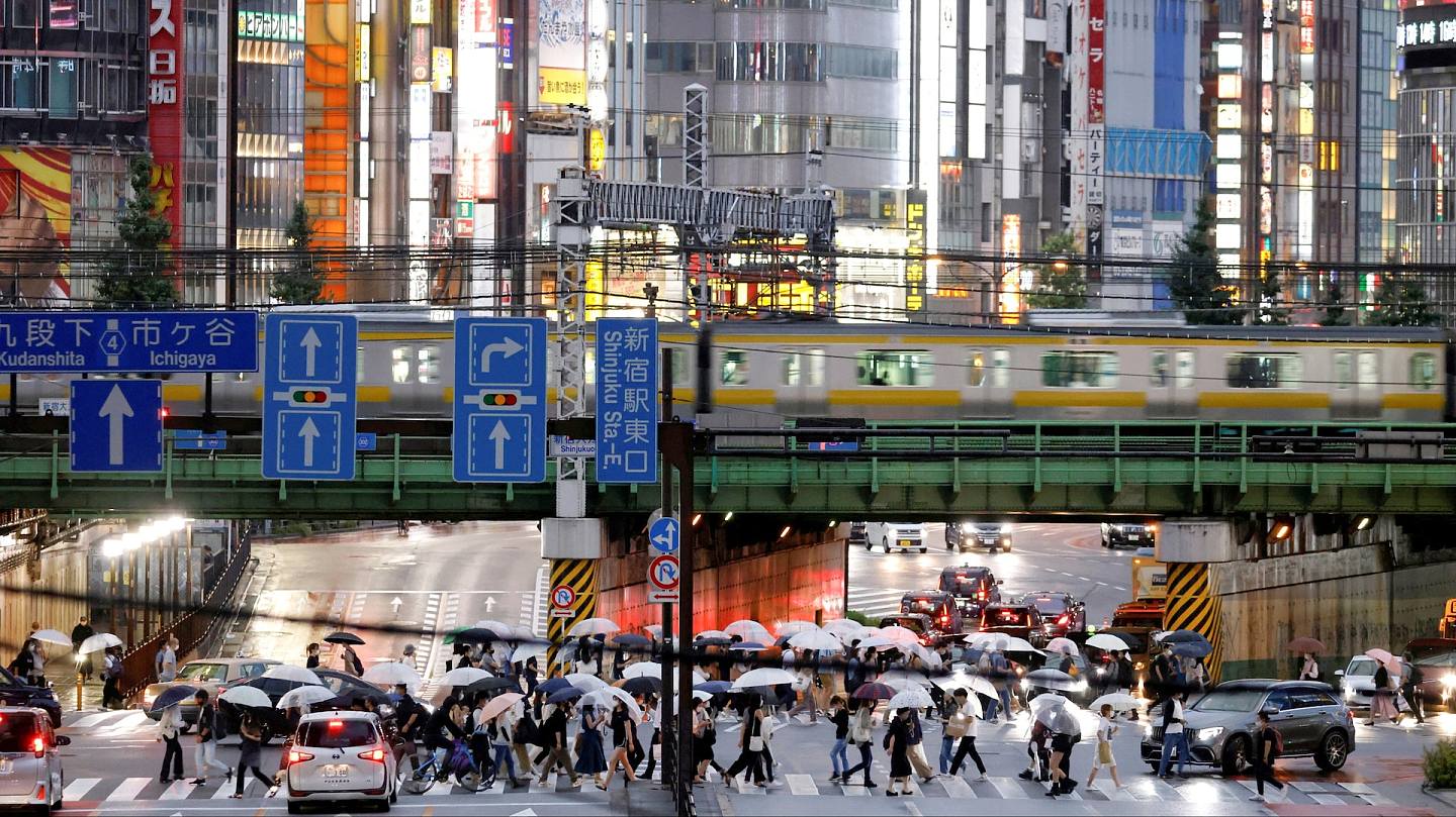 日本新冠肺炎疫情：圖為2021年8月14日，走在東京新宿站旁馬路的行人。（Reuters）