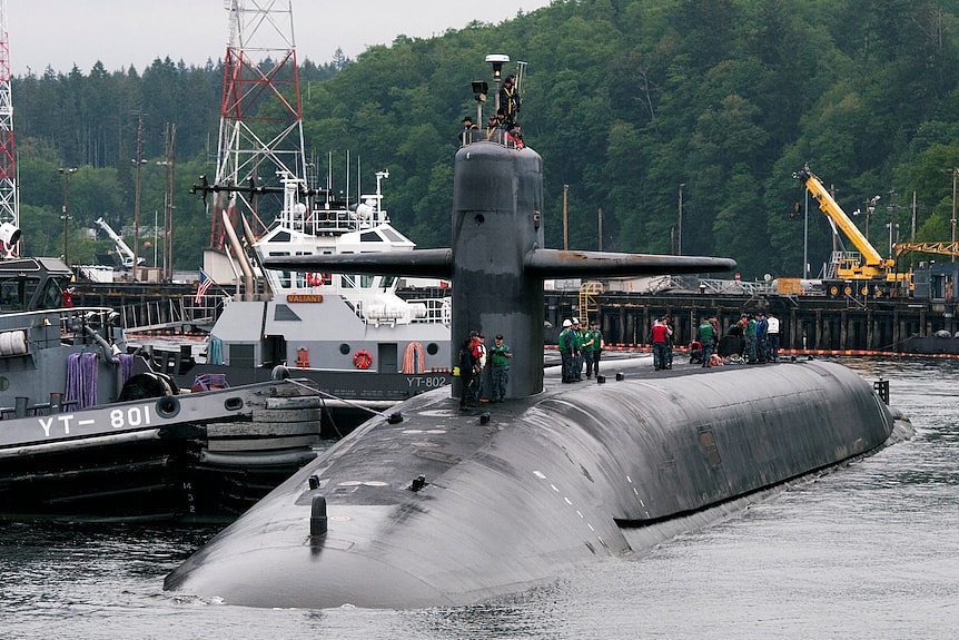 An Ohio-class submarine sits at a naval dock.