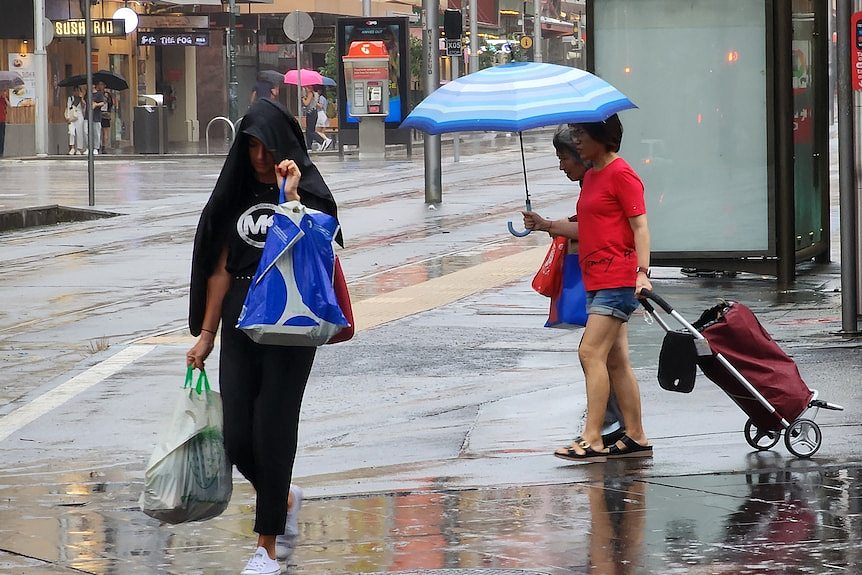 people walking on the streets carrying umbrellas 