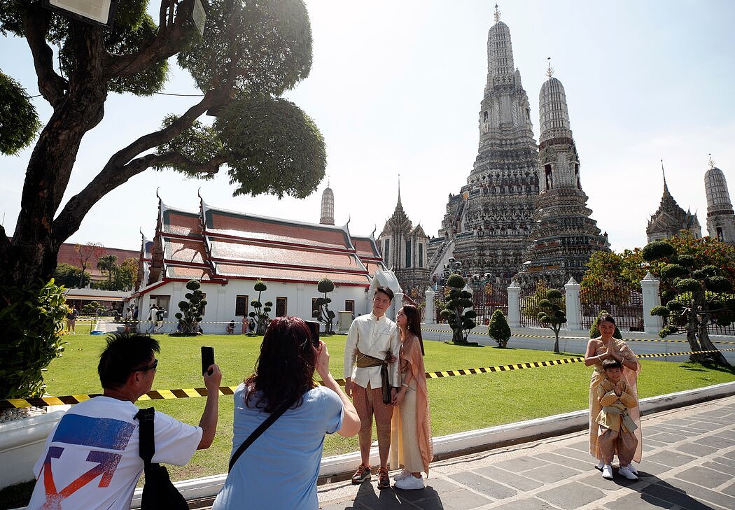 身穿租借的泰国传统服装留影的中国游客，今年1月摄于曼谷。