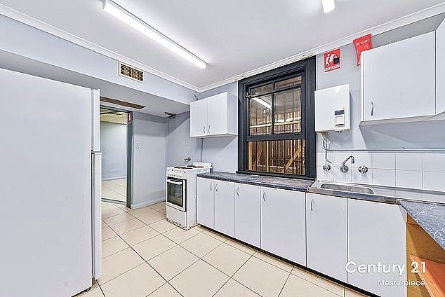 The entire property has tiled floors but looks more like an office space with a run-down kitchen than a family home