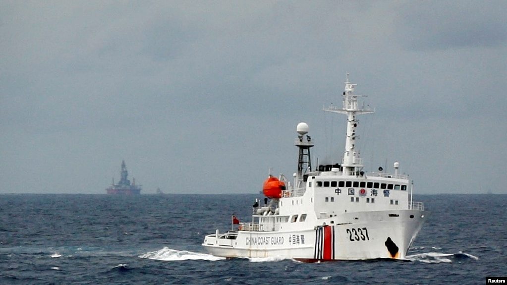 资料照：一艘中国海警船在南中国海上的一座中国海上钻井平台旁驶过。（2014年6月13日）