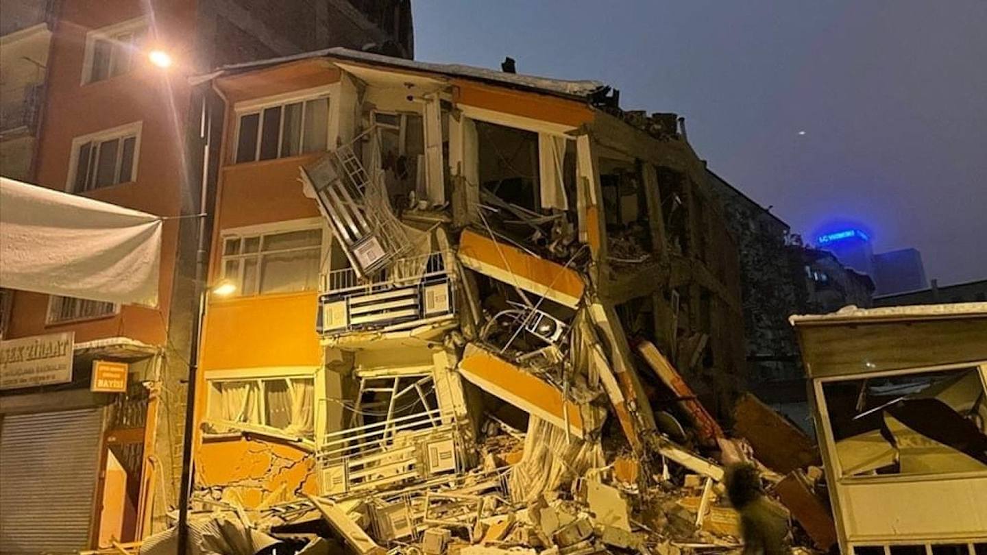 土耳其地震：A man walks past by a collapsed building after an earthquake in Malatya, Turkey February 6, 2023.  （Reuters）