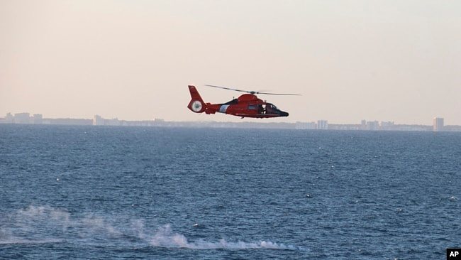 美国海军提供的图片显示美国海岸警卫队直升机在回收中国高空侦察气球残骸行动期间飞过碎片散落区。(2023年2月4日)